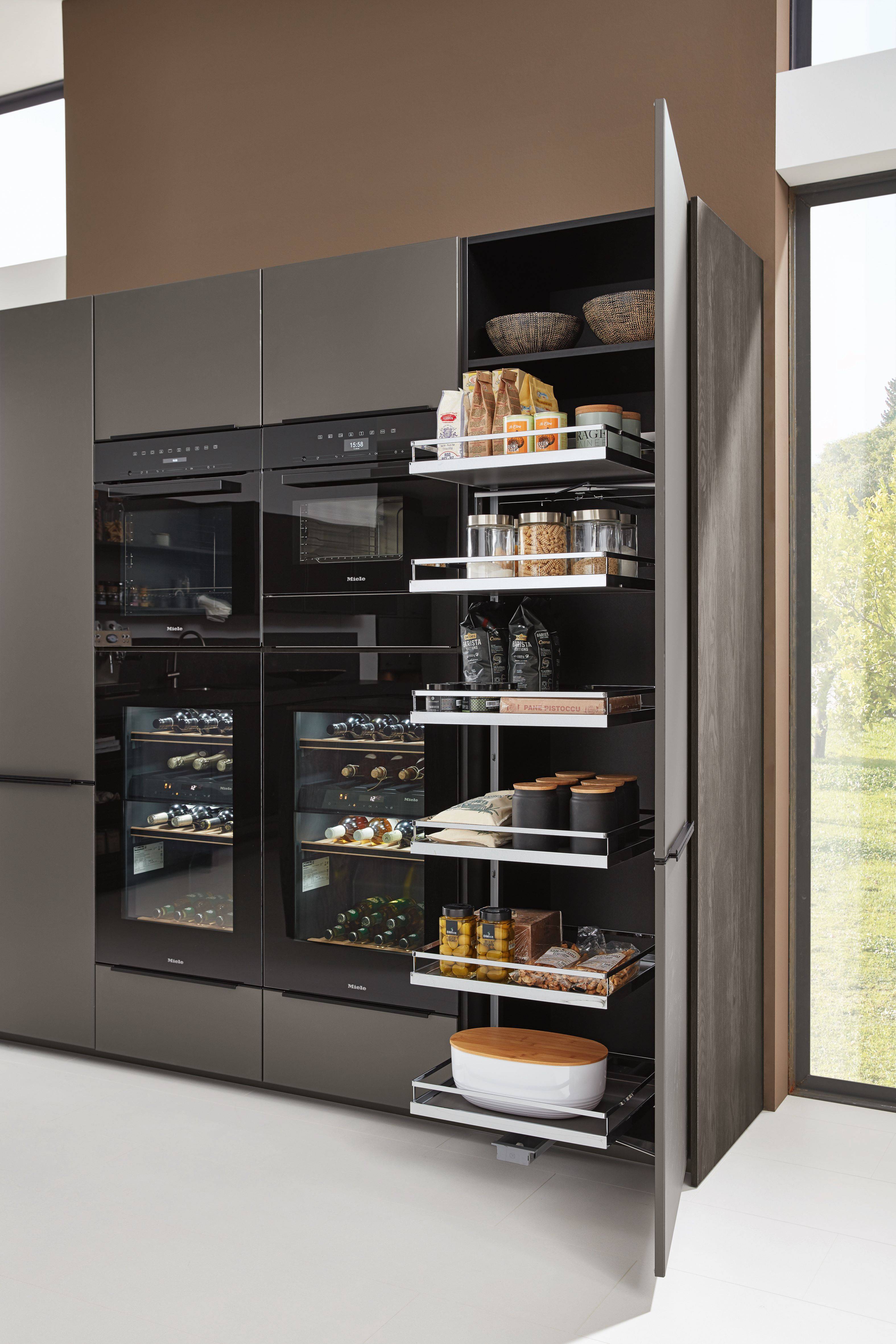 Moderner Küchenhochschrank mit geöffnetem Auszugssystem und eleganten schwarzen Geräten.